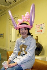 Balloon hat with bunny ears and a teddy bear.