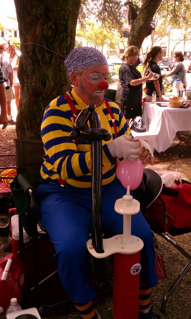 The pirate clown makes a sword balloon.