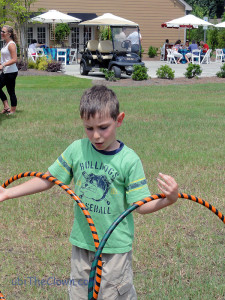 Sword-fighting boy figures out how to hoop one hoop on each hand.